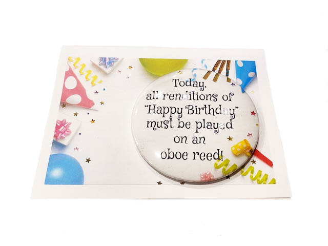 Happy birthday oboe reed badge and card on white background