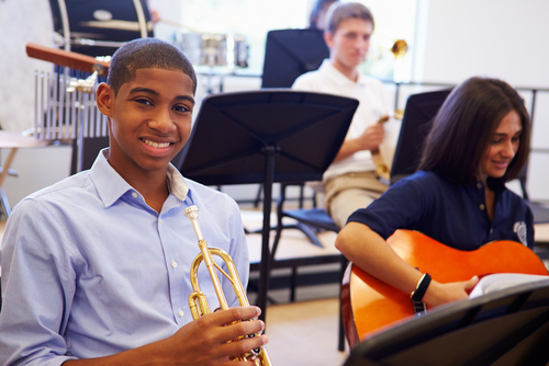 boy playing trumpet next to girl on guitar