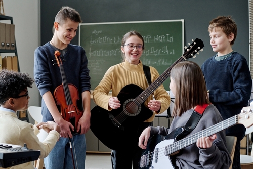 musical peers are important group of teenaged boys and girls playing instruments and having fun